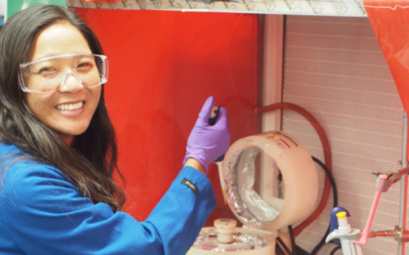 Teacher smiles at camera while pipetting